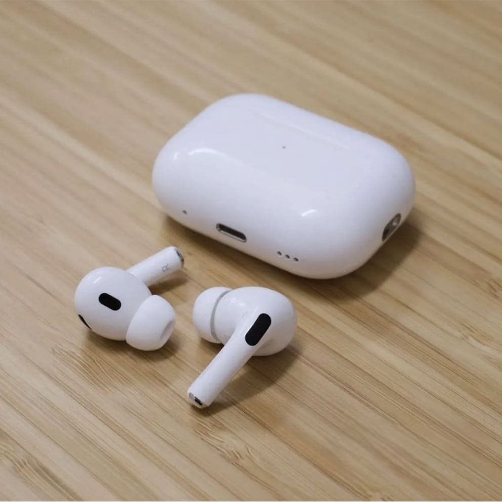 White wireless earbuds with charging case on a wooden surface