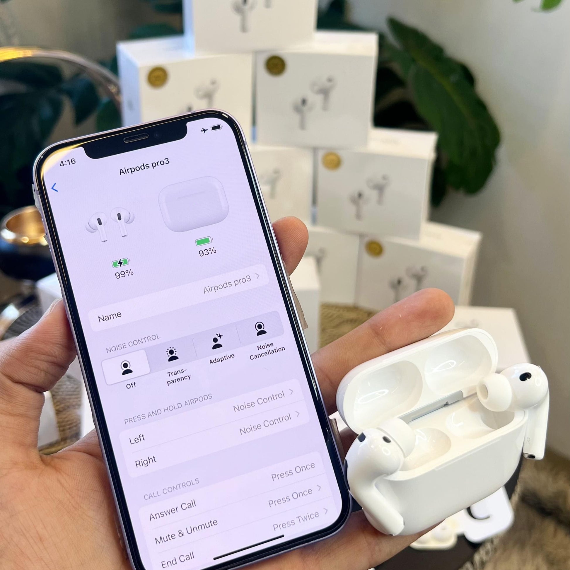 Person holding a smartphone with Adipods Pro 3 displayed on the screen, with Adipods Pro 3 case in hand.